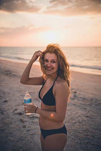 person woman in black bikini standing near ocean human