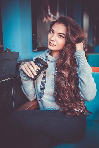 human woman in gray pullover hoodie sitting on sofa person