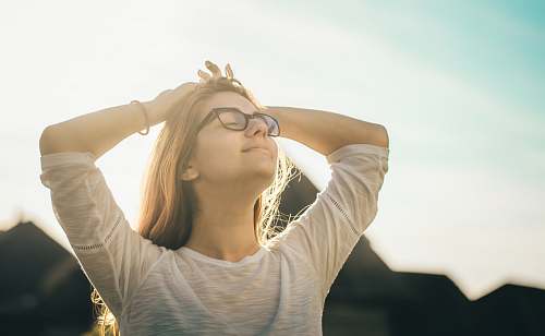 human woman in white crew-neck T-shirt holding her head person