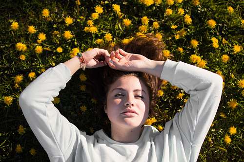 person woman in white top laying on flowers caucasian