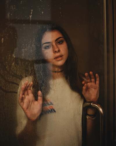 person woman leaning on glass door human