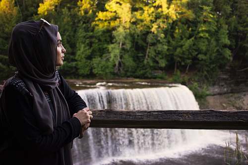 person woman leaning on railings near waterfalls human
