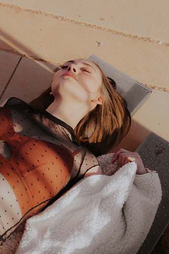 human woman lying on brown concrete pavement person