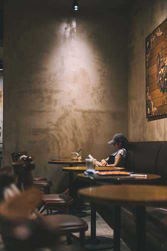 human woman reading book inside coffee shop chair