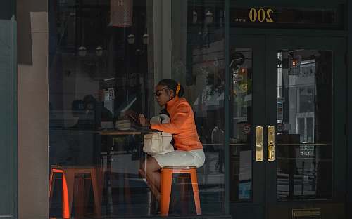 person woman sitting in front of brown table door