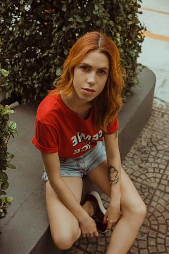 human woman sitting near bush plant person