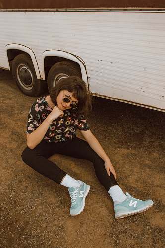 human woman sitting near white bus during daytime person