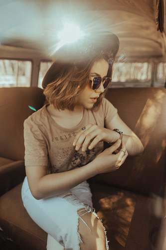 person woman sitting on car seat while looking at her watch human