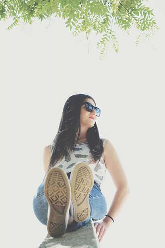 human woman sitting on concrete surface with white background person