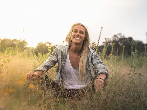 human woman sitting on grass field woman