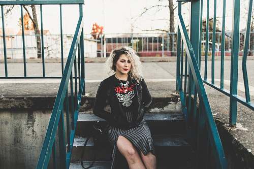 person woman sitting on gray concrete stairs railing