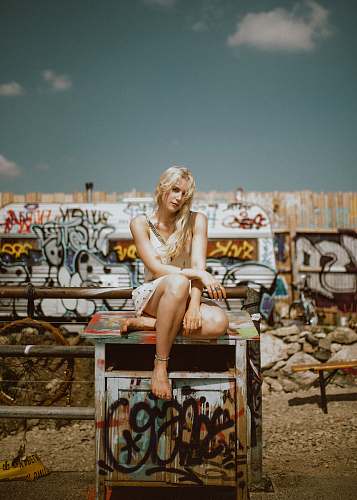 graffiti woman sitting on multicolored end table outdoor girl
