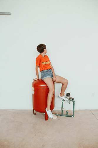 human woman sitting on red metal tank person