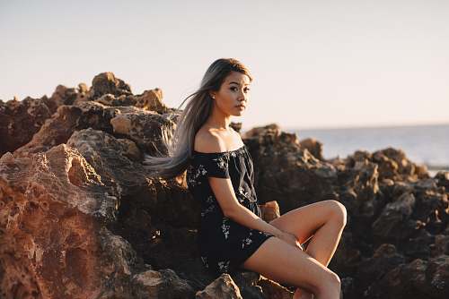 human woman sitting on rock person