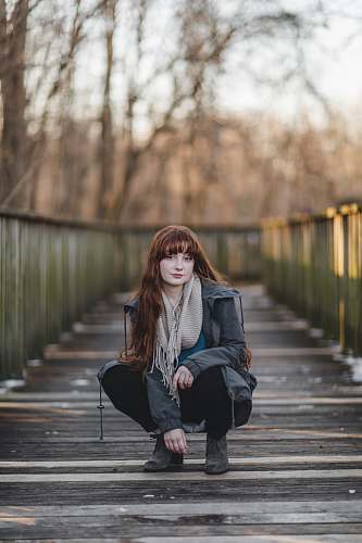 person woman sitting on wooden bridge human