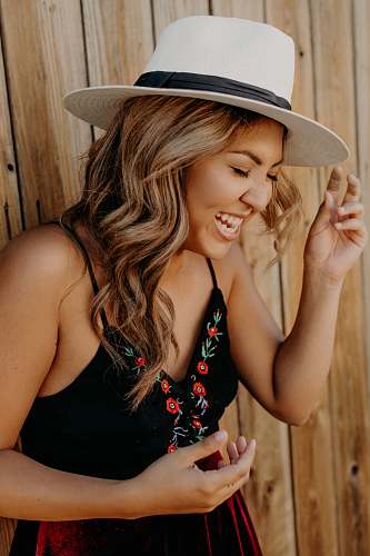 human woman smiling while closing her eyes hat