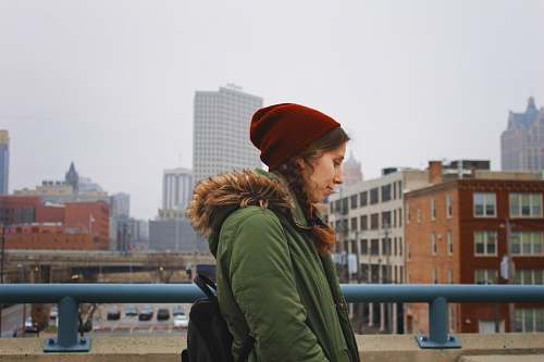 person woman standing beside blue rail human