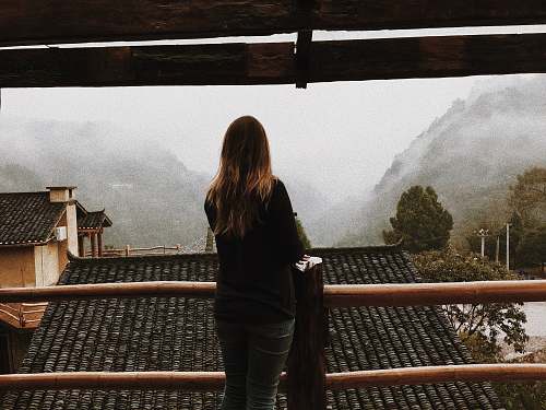 human woman standing in front of handrail roof