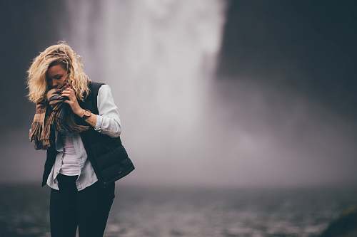 human woman standing in front of waterfall woman