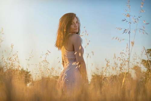 human woman standing in the middle of brown grass person