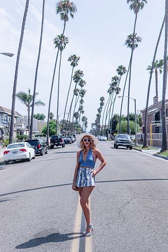 human woman standing in the middle of road between trees person