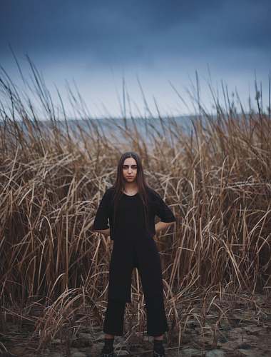 person woman standing near brown grass field human