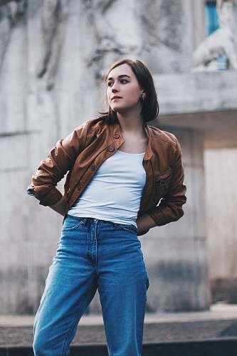 human woman standing near gray wall during daytime person