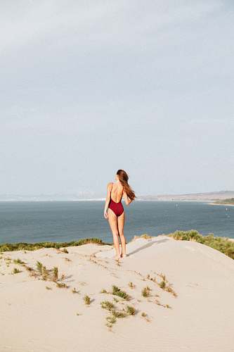 person woman standing near mountain cliff swimwear