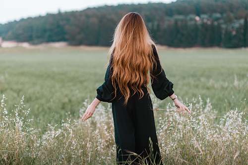 person woman standing on green grass field during daytime woman