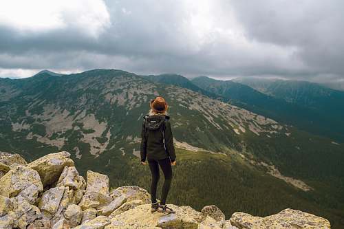mountain woman standing on rock facing mountains mountain range