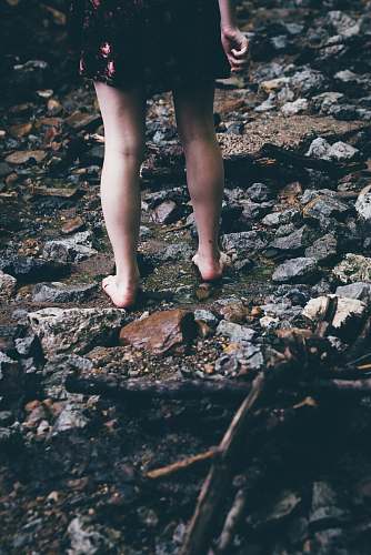 person woman standing on rocks with water flowing rocks