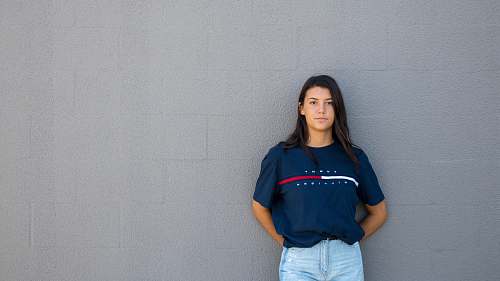 person woman standing while leaning on wall human