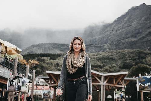 person woman wearing black denim bottoms standing near building human