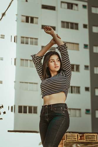 person woman wearing gray and black striped long-sleeve shirt holding her wrist human