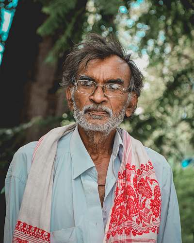 human close-up photo of man in white and red floral scarf people