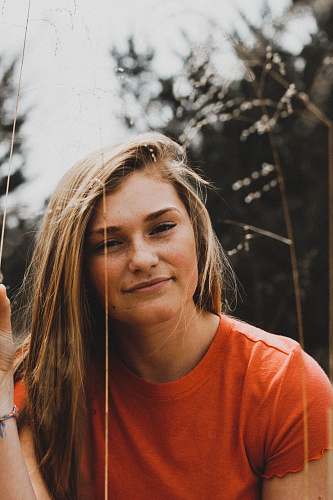 human close-up photo of woman in orange crew-neck shirt people
