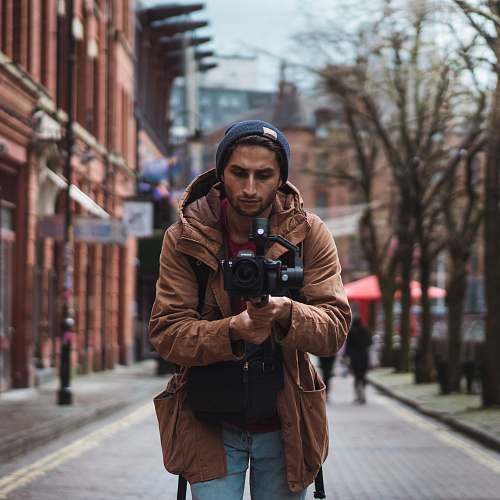 human depth of field photography of man holding camera people