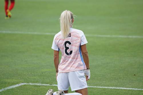 human female soccer player standing at field people
