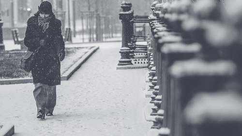 people grayscale photo of person walking on street grey