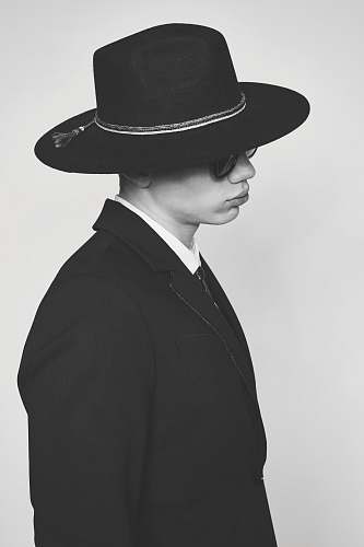 black-and-white grayscale photo of person's blazer hat