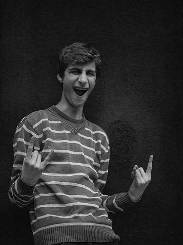 human grayscale photography of man wearing gray and white striped sweater black-and-white