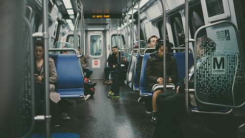 subway group of person sitting on blue chairs train