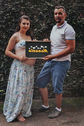 people man and woman holding manuela signage during daytime human