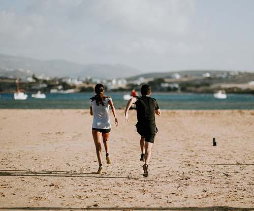 human man and woman running on brown field people