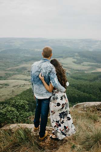 people man and woman standing on cliff during daytime human