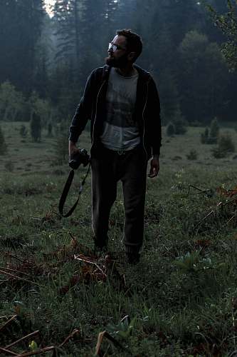human man holding camera on grass field people
