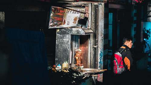 people man in black jacket with red backpack standing near gyro machine human