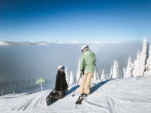snowboarding man in green snow jacket and brown pants snow