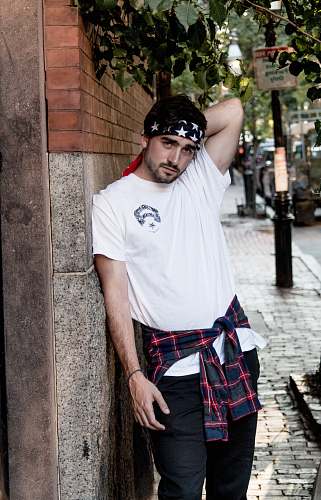 plaid man in white shirt leaning against wall portrait