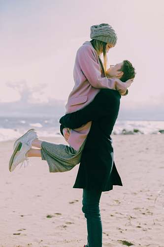 human man lifting woman while doing face to face people